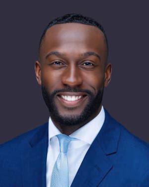 Commissioner Darius Beckham smiling in a blue suit.